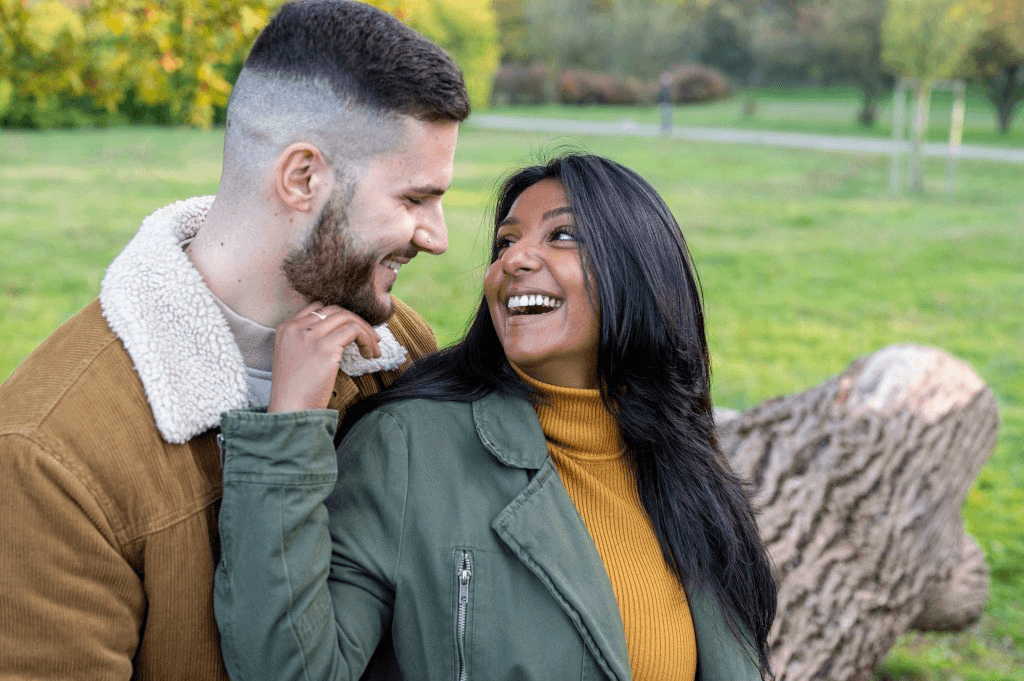 A warm couple laughing together in a park